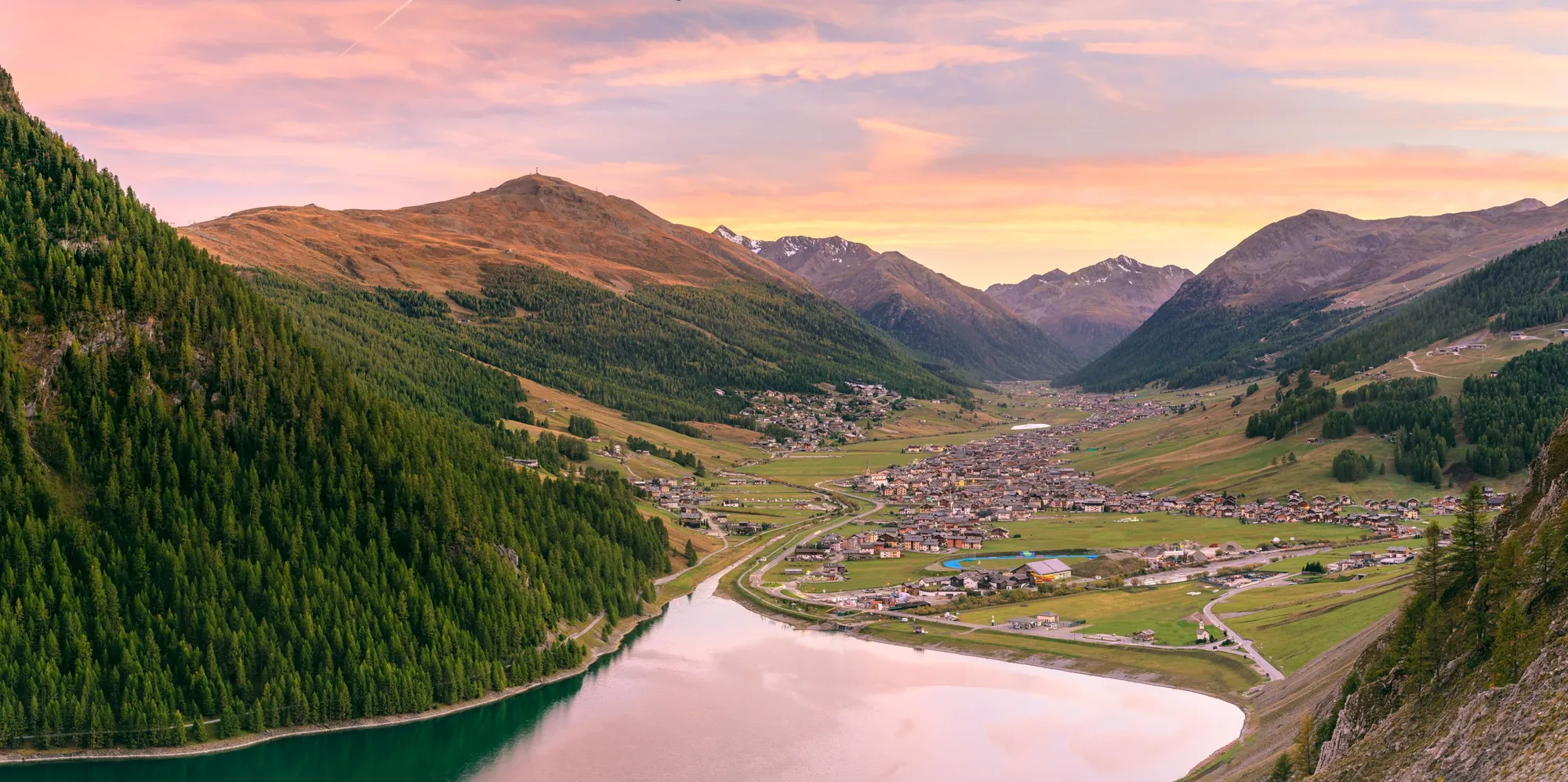 Het Lago di Livigno bij zonsondergang met roze lucht