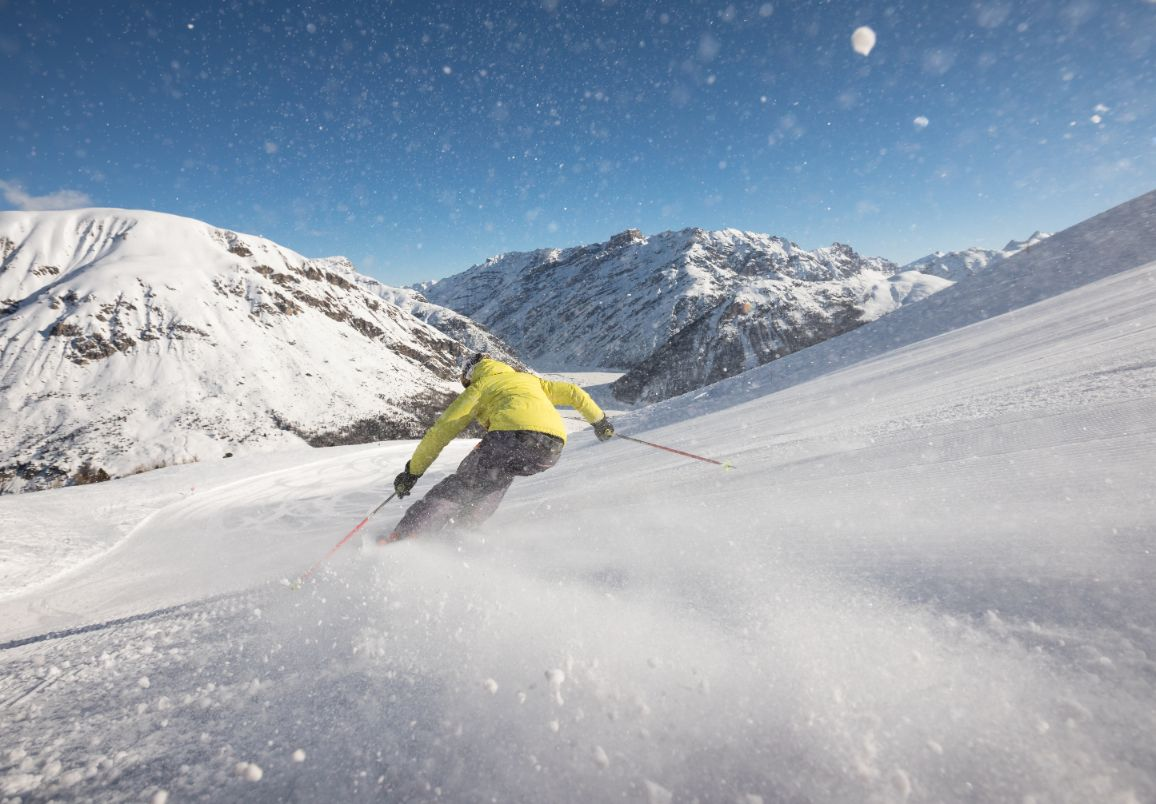 Skier geniet van de zon op de piste in Livigno