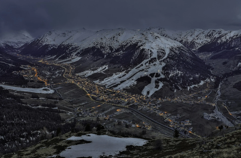 Livigno in de avond met verlichte straten en besneeuwde bergen