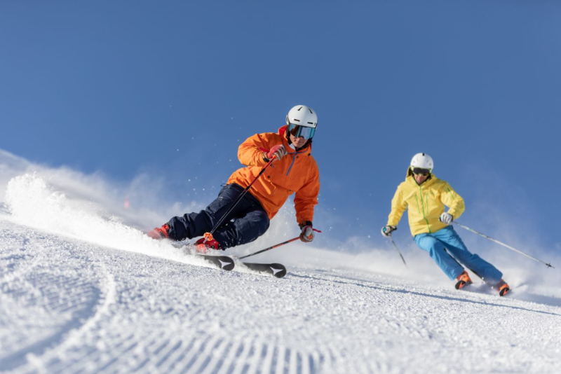 Twee skiers dalen af op de piste in Livigno